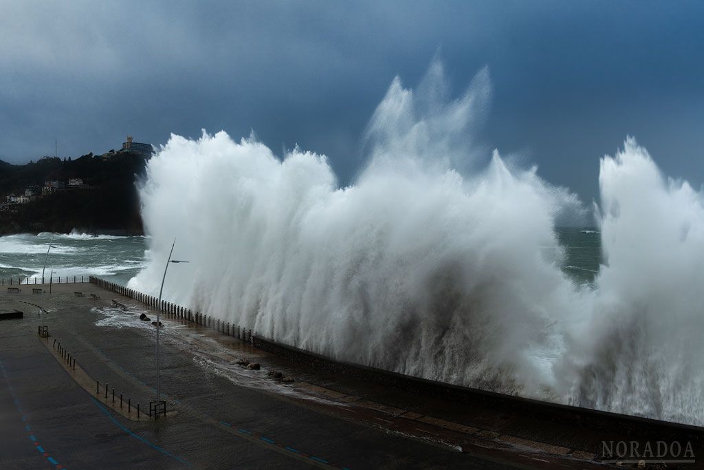 Olas rompiendo en el Paseo Nuevo con el monte Igueldo de fondo