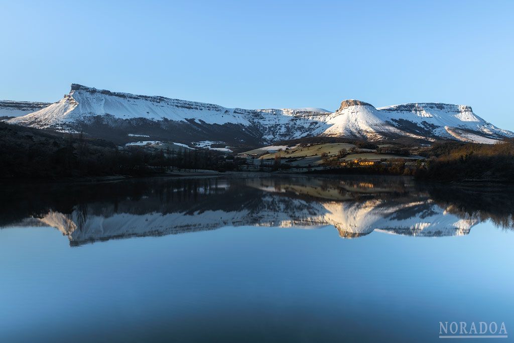 La sierra Salvada/Gorobel nevada se refleja en embalse de Maroño