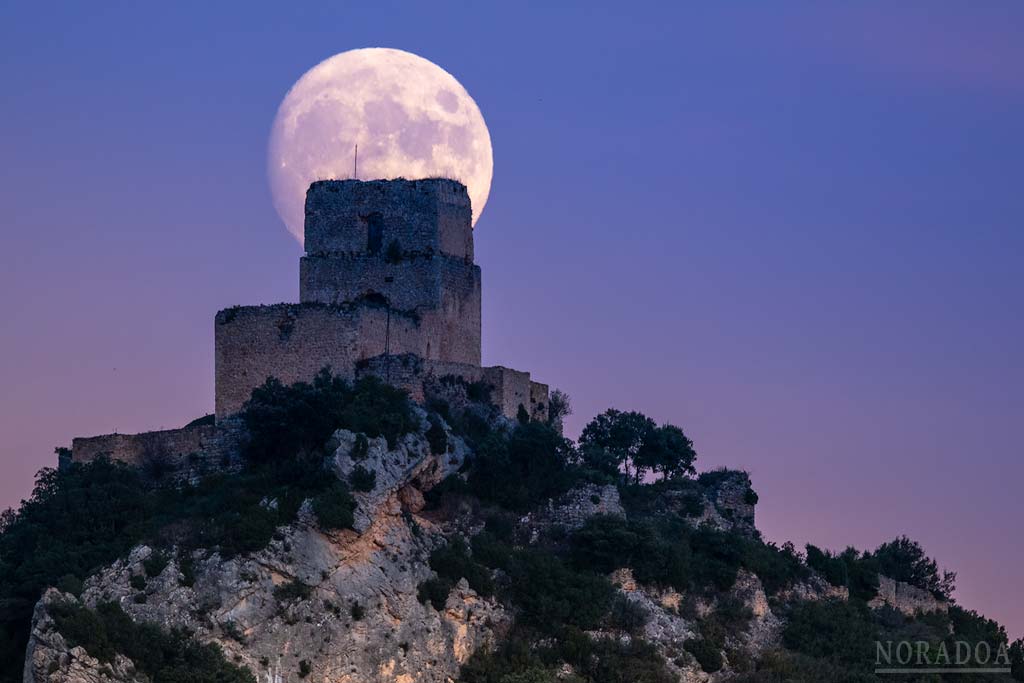 La luna saliendo detrás del castillo de Lanos en el pueblo alavés de Ocio